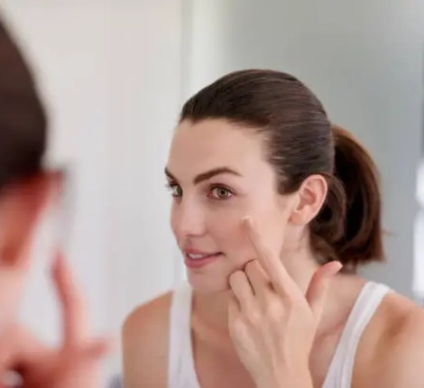 Shot of an attractive young woman applying moisturiser in front of a bathroom mirror