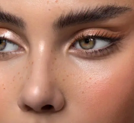 Closeup studio shot of a beautiful teenage girl with freckles skin posing against a grey background